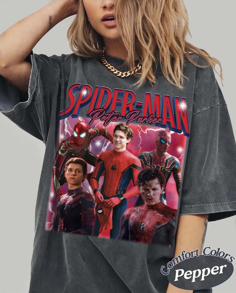 May include: Dark gray t-shirt featuring multiple images of Spider-Man and the text "SPIDER-MAN Peter Parker" in red and blue. The shirt has a vintage look with the words "Comfort Colors Pepper" printed on the bottom right.