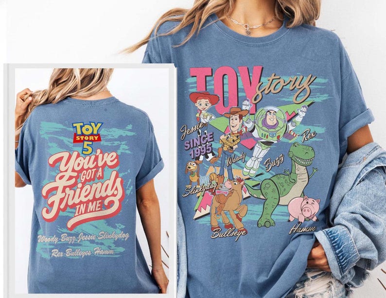 Pode incluir: Uma t-shirt azul com gr&aacute;ficos de Toy Story. A frente mostra as personagens Woody, Buzz Lightyear, Jessie, Rex, Hamm, Bullseye e Slinky Dog com o texto "TOY story". As costas apresentam o texto "TOY STORY 5 You've Got A Friends In Me".
