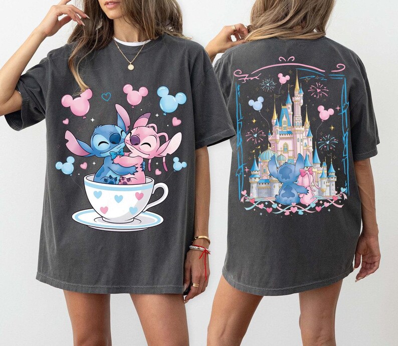 Pu&ograve; includere: T-shirt grigio scuro con un'illustrazione a cartoni animati di Stitch e Angel che si abbracciano in una tazza da t&egrave;, circondati da cuori e palloncini. Il retro della maglietta mostra una scena del castello con Stitch e Angel, fuochi d'artificio e palloncini.