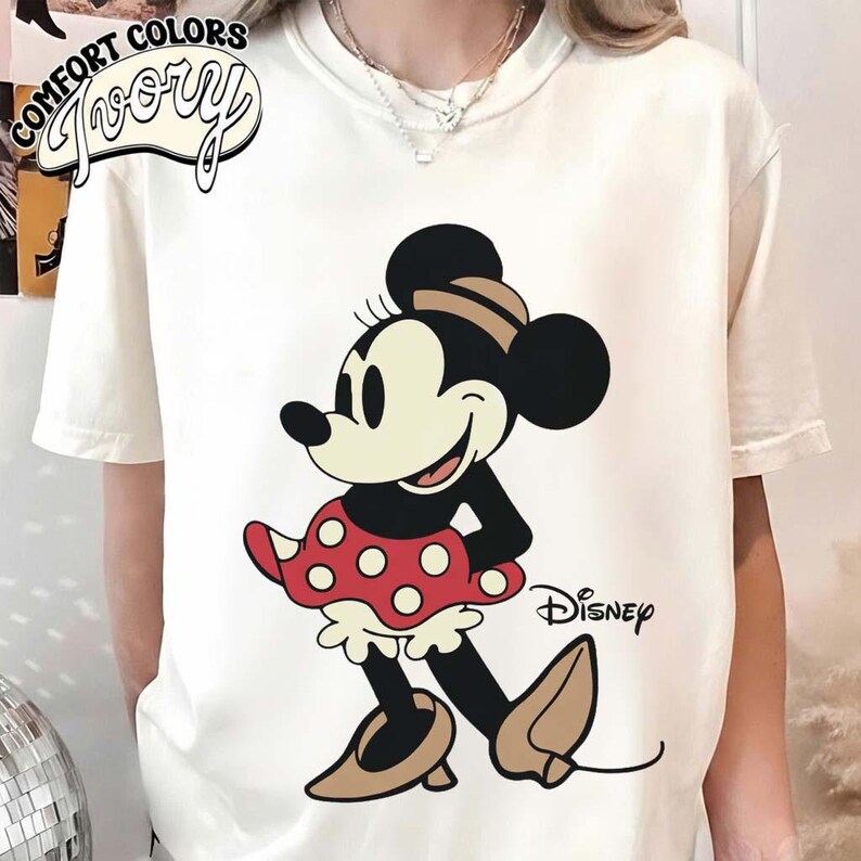 May include: A white ceramic mug with a black handle and the text "But First, Coffee" in a bold, black font. The mug is set against a blurred background, suggesting a cozy setting.