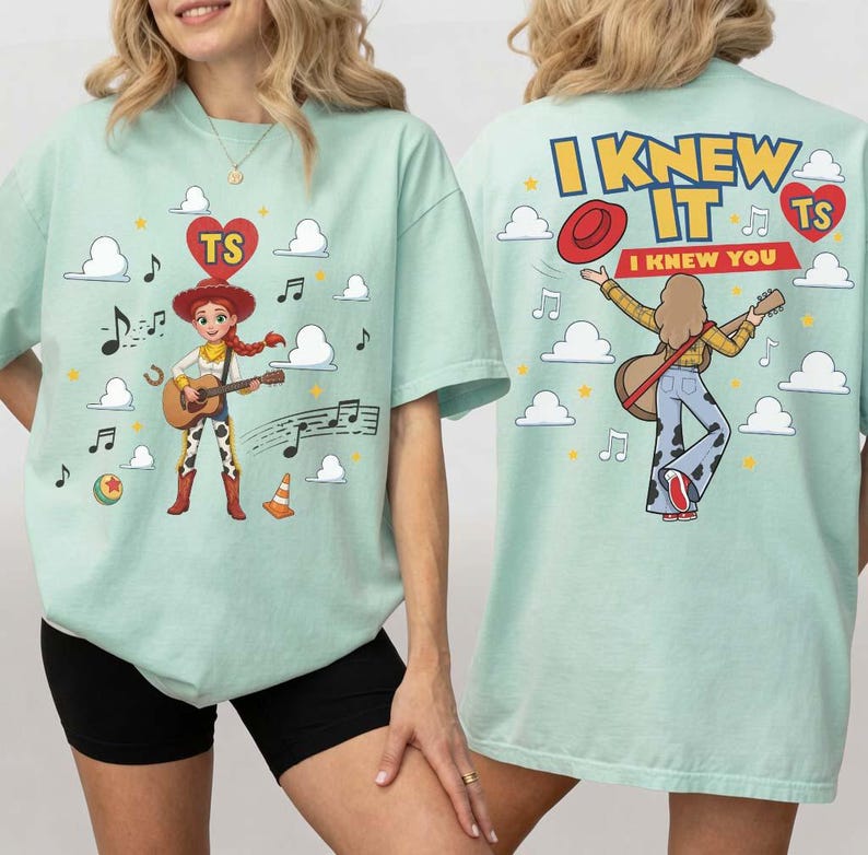 Puede incluir: Una camiseta verde claro con un gr&aacute;fico de un personaje vaquero tocando la guitarra en la parte delantera, rodeado de nubes, notas musicales y un coraz&oacute;n con las letras TS. La parte trasera muestra el texto I KNEW IT y I KNEW YOU con un personaje.
