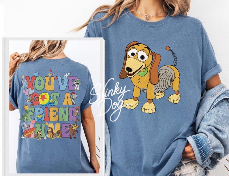 May include: A blue t-shirt featuring a graphic of Slinky Dog on the front and a colorful design on the back with the text "YOU'VE GOT A FRIEND IN ME" surrounded by various cartoon characters including Buzz Lightyear, Woody, and Rex.