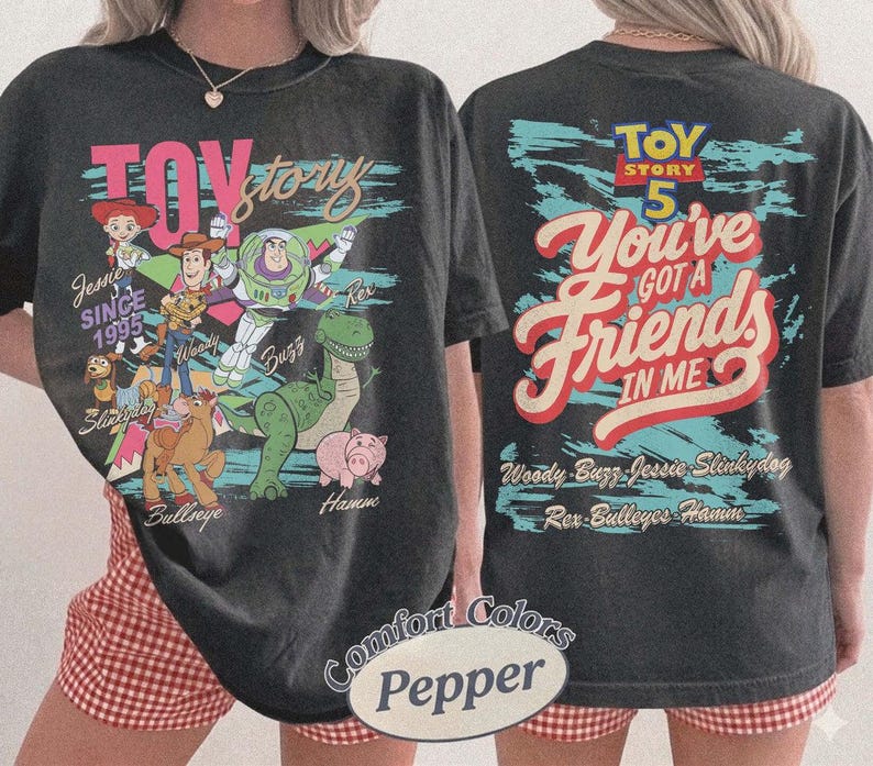Pode incluir: Uma t-shirt preta com gr&aacute;ficos de Toy Story. A frente mostra Woody, Buzz Lightyear, Jessie, Slinky Dog, Bullseye e Hamm com o texto Toy Story Since 1995. As costas apresentam o texto Toy Story 5 You've Got A Friends In Me.