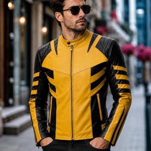 May include: A yellow and black leather jacket featuring a mandarin collar, a full-length front zipper, and quilted shoulder detailing. The design includes bold black geometric panels across the chest, sleeves, and sides, with a slim-fit silhouette.
