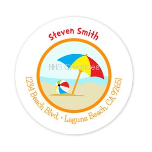 May include: Round sticker with an orange border and a beach scene inside. The scene includes a beach umbrella with blue, yellow, and red stripes, a beach ball, and a sandy beach. The text "Steven Smith" is at the top of the sticker, and the address "1234 Beach Blvd. Laguna Beach, CA 92651" is around the border.