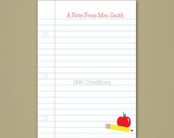 May include: A printable note paper template with a red apple and yellow pencil illustration. The paper has blue lines and red margins. The text "A Note From Mrs. Smith" is at the top of the page and "NHA Creatives" is in the center of the page.