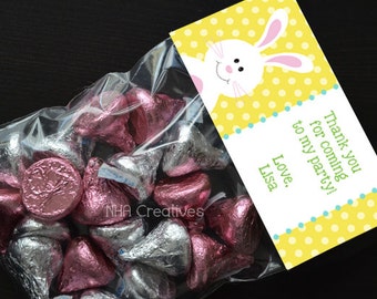 May include: A clear plastic bag filled with pink and silver foil-wrapped chocolate kisses. A yellow and white tag with a white bunny and polka dots reads "Thank you for coming to my party! Love, Lisa."