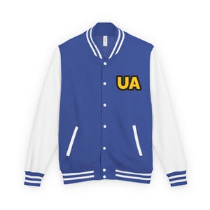 May include: A blue and white varsity jacket with the letters "UA" in yellow and black on the chest. The jacket has white sleeves, a white collar, and white stripes on the cuffs and hem.
