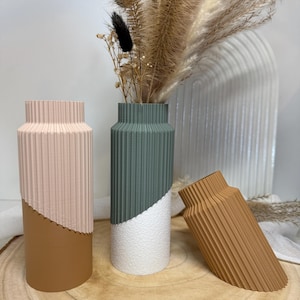 May include: A white ceramic mug with a black handle and the text "But First, Coffee" in a bold, black font. The mug is set against a blurred background, highlighting its clean design. The mug is approximately 10 cm tall.