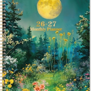 May include: A spiral-bound monthly planner with a nature-themed cover. The cover features a full moon, forest, and wildflowers. Gold text reads "26-27 Monthly Planner". The planner has a gold spiral binding.