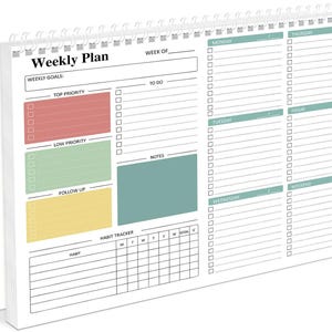 May include: A white spiral-bound weekly planner with a colorful layout. The planner features sections for weekly goals, to-do lists, notes, and a habit tracker. The planner has a red, green, yellow, and teal color scheme.