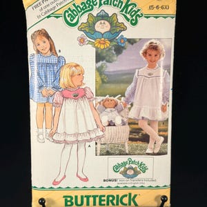 Pode incluir: Um envelope de molde de costura Butterick para roupas de Cabbage Patch Kids, tamanho 5-6X. A frente apresenta ilustrações de crianças vestindo vestidos com mangas xadrez azuis e corpete branco, junto com uma boneca com roupa combinando.