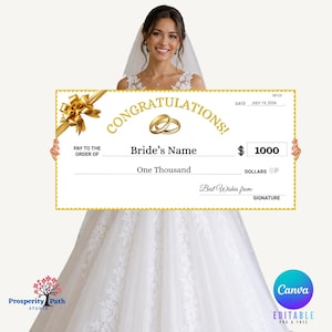 May include: A large, rectangular, white novelty cheque featuring a gold border, a gold ribbon graphic, and two gold wedding rings. The text reads CONGRATULATIONS, PAY TO THE ORDER OF, Bride's Name, 1000, One Thousand, DATE JULY 19, 2026, and SIGNATURE.
