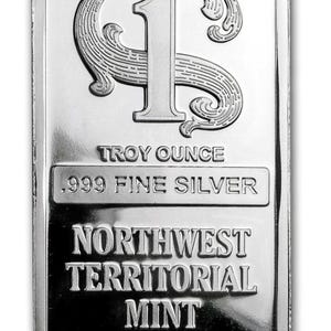 May include: A rectangular silver bar with rounded corners. The bar features an ornate "1" and "S" design at the top. Text includes "TROY OUNCE", ".999 FINE SILVER", "NORTHWEST TERRITORIAL MINT", and "DAYTON, NV".