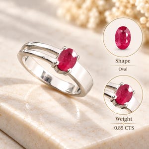 Macro close-up of a natural ruby ring highlighting the oval gemstone, pinkish red color, faceted surface and secure prong setting. The detailed jewelry photograph shows the character of the 0.69 ct natural ruby and the polished silver-tone band at close range. Ideal for buyers searching for an oval ruby ring, natural gemstone ring, red gemstone jewelry, July birthstone ring, minimalist ruby jewelry, anniversary gift for her or a meaningful gemstone keepsake with timeless styling.
