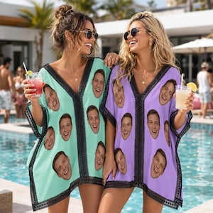 Puede incluir: Dos túnicas de playa con cuello en V que presentan un patrón repetitivo del rostro de un hombre sonriente. Una túnica es de color verde menta y la otra es de color violeta claro. Ambas prendas tienen encaje negro en el cuello y las mangas.