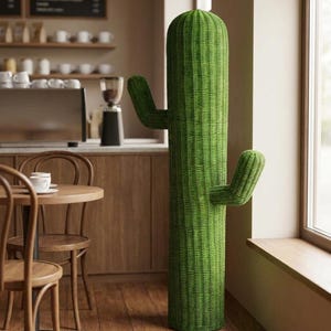 May include: A tall, floor-standing cactus sculpture crafted from woven green material. The structure features a cylindrical main body with two upward-curving arms extending from the sides, showcasing a detailed, textured, basket-like weave pattern.