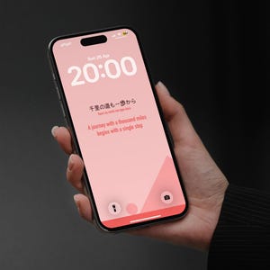 Peut inclure: Un smartphone avec un écran rose affichant l'heure 20h00 et la date du 26 avril. L'écran présente du texte japonais et la phrase anglaise, "A journey with a thousand miles begins with a single step."