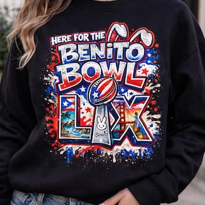 May include: Black sweatshirt with a colorful graphic that reads "HERE FOR THE BENITO BOWL LX." The design includes a football, a trophy with a bunny, and images of a beach and a bridge, with red, white, and blue accents.