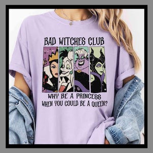 May include: A lilac t-shirt featuring the words "BAD WITCHES CLUB" and the phrase "WHY BE A PRINCESS WHEN YOU COULD BE A QUEEN?" above four cartoon villain portraits.