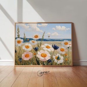 Könnte beinhalten: Gerahmtes Gemälde eines Gänseblümchenfeldes unter blauem Himmel mit Wolken. Die Gänseblümchen haben weiße Blütenblätter und orangefarbene Zentren, mit einigen rosa und blauen Akzenten. Das Kunstwerk ist unten rechts mit "GRAPHIE" signiert.
