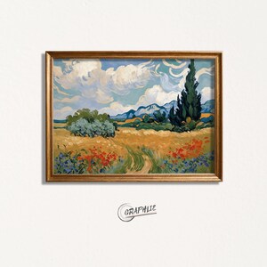 May include: A framed art print depicting a rural landscape with a wheat field, red poppies, and a path under a blue sky with clouds. The artwork is in a gold frame and includes the word "GRAPHIE".