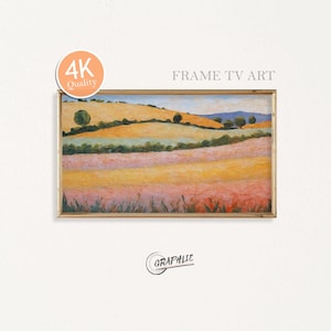 Pode incluir: Pintura de paisagem emoldurada com uma moldura dourada. A obra retrata colinas onduladas em tons de amarelo, laranja e rosa, com árvores verdes e um céu azul. O texto "FRAME TV ART" é visível.