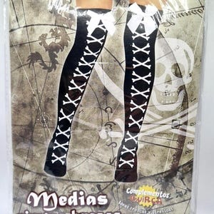 Puede incluir: Medias negras hasta el muslo con diseño de huesos blancos y lazo blanco en la parte superior. El empaque incluye el texto "Medias piratas huesos" y "Stocking". Las medias están diseñadas para un disfraz de pirata.
