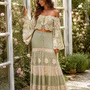 K&ouml;nnte beinhalten: Zweiteiliges H&auml;kel-Outfit in Gr&uuml;n- und Cremet&ouml;nen. Das schulterfreie Oberteil hat lange, ausgestellte &Auml;rmel und eine Schn&uuml;rung vorne. Der Rock ist ein gestufter Maxirock mit floralen Details, f&uuml;r einen Boho-Look.