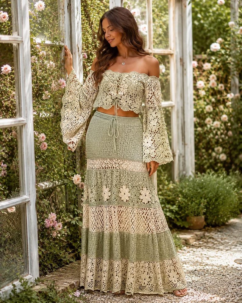 K&ouml;nnte beinhalten: Zweiteiliges H&auml;kel-Outfit in Gr&uuml;n- und Cremet&ouml;nen. Das schulterfreie Oberteil hat lange, ausgestellte &Auml;rmel und eine Schn&uuml;rung vorne. Der Rock ist ein gestufter Maxirock mit floralen Details, f&uuml;r einen Boho-Look.