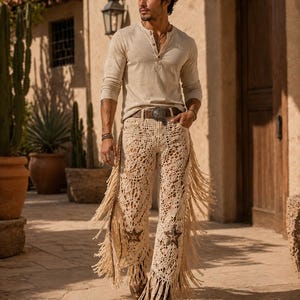 May include: A beige long-sleeved Henley shirt paired with cream-colored crochet pants featuring star accents and long fringe. The outfit is completed with a brown belt and boots, creating a bohemian western aesthetic.
