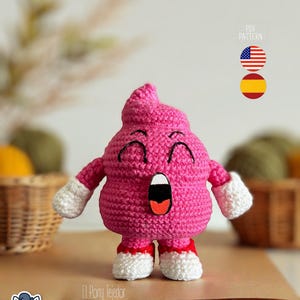Puede incluir: Una figura rosa hecha a mano con ganchillo, con una cara sonriente, boca abierta y brazos y piernas pequeños. La figura tiene guantes y zapatos blancos con suelas rojas. El texto "PDF PATTERN" y banderas están en el fondo. El texto "El Pony Tejedor" está en la parte inferior.