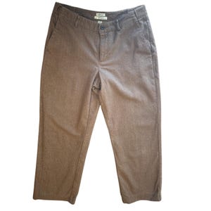 May include: Solid brown trousers featuring a mid-rise waist, a button and zipper fly closure, belt loops, and two side pockets. The pants have a straight-leg cut and a visible L.L.Bean brand label sewn inside the waistband at the center back.
