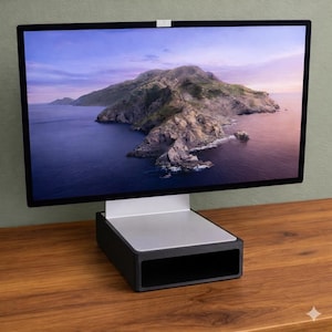 May include: A modern computer monitor with a black bezel displays a scenic landscape of an island and ocean. The monitor sits on a silver and black stand, placed on a wooden surface. The screen has a white cover at the top.