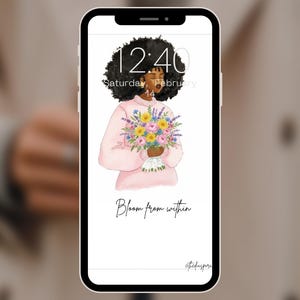 Può includere: Uno smartphone mostra un'illustrazione digitale di una persona con capelli scuri e ricci che tiene in mano un mazzo di fiori. La persona indossa un maglione rosa. Lo schermo mostra l'ora 12:40 e la data sabato 14 febbraio. Il testo "Bloom from within" è visibile.