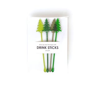 May include: A set of four drink sticks in a white package. Each stick features a tree-shaped design in shades of green, with glitter accents. The package reads "dress up your beverage with DRINK STICKS set of 4."