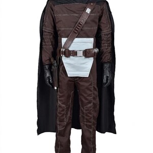 May include: A brown costume with a black cape, gloves, and a utility belt. The costume features a high collar, a white panel at the waist, and a holster for a sidearm. The outfit is designed with visible stitching and a shoulder strap.