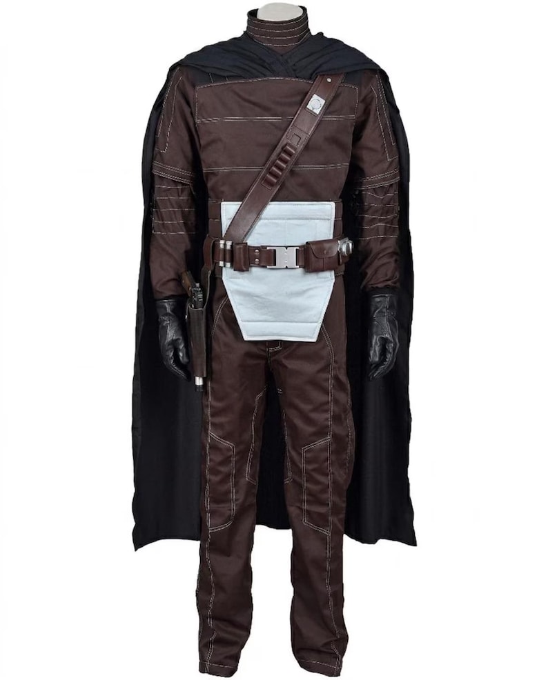 May include: A brown costume with a black cape, gloves, and a utility belt. The costume features a high collar, a white panel at the waist, and a holster for a sidearm. The outfit is designed with visible stitching and a shoulder strap.