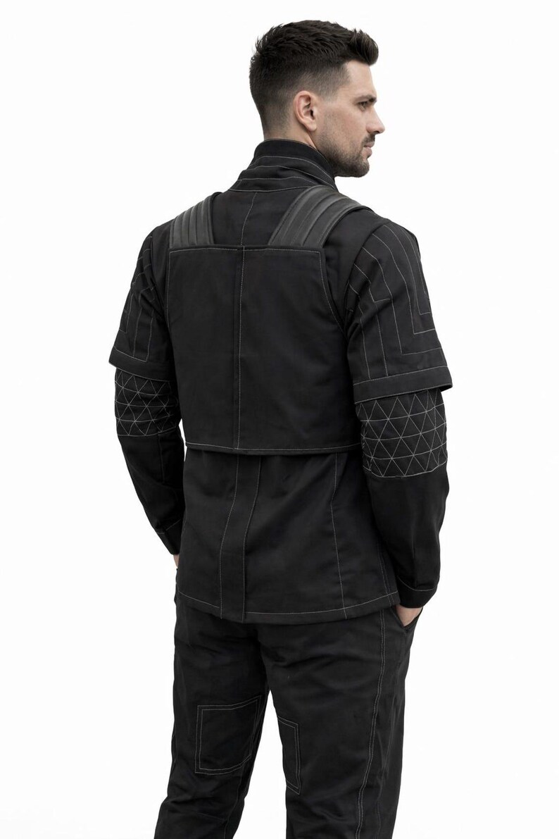 Puede incluir: Chaqueta y pantal&oacute;n negros con costuras blancas. La chaqueta tiene un dise&ntilde;o &uacute;nico con patrones geom&eacute;tricos en las mangas y los hombros. El conjunto parece estar hecho de una tela duradera, posiblemente t&eacute;cnica.