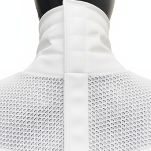 Może przedstawiać: Biały kołnierz szermierczy z siatkowym śliniakiem i wyściełanym, pionowym kołnierzem. Kołnierz posiada centralny, pionowy pasek z zapięciem na zatrzask. Siatkowy śliniak ma chronić szyję i klatkę piersiową podczas szermierki.