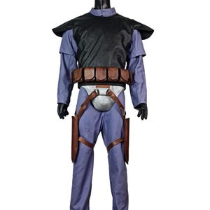 K&ouml;nnte beinhalten: Ein komplettes Kost&uuml;m auf einer Schaufensterpuppe. Es besteht aus einer schwarzen Weste, einem hellblauen Hemd und einer Hose sowie einem braunen G&uuml;rtel mit Taschen. Braune Holster sind an den Beinen befestigt. Das Kost&uuml;m hat ein futuristisches oder Science-Fiction-Design.