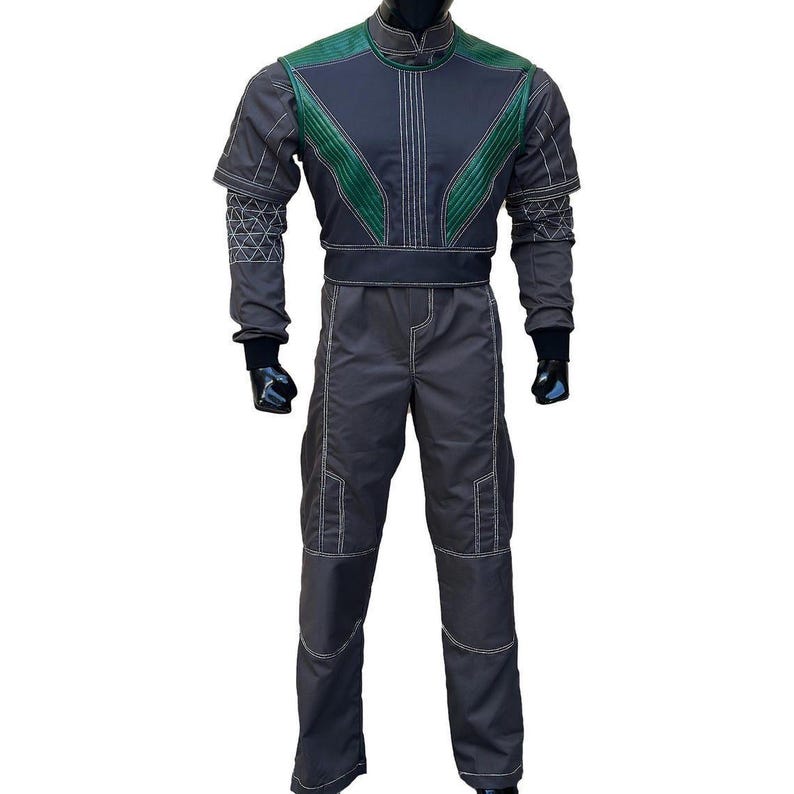 Puede incluir: Mono gris oscuro con detalles verdes en los hombros y el pecho. El traje presenta costuras blancas y guantes negros. El atuendo est&aacute; dise&ntilde;ado con un cuello alto y una cintura ajustada, adecuado para cosplay o eventos de disfraces.