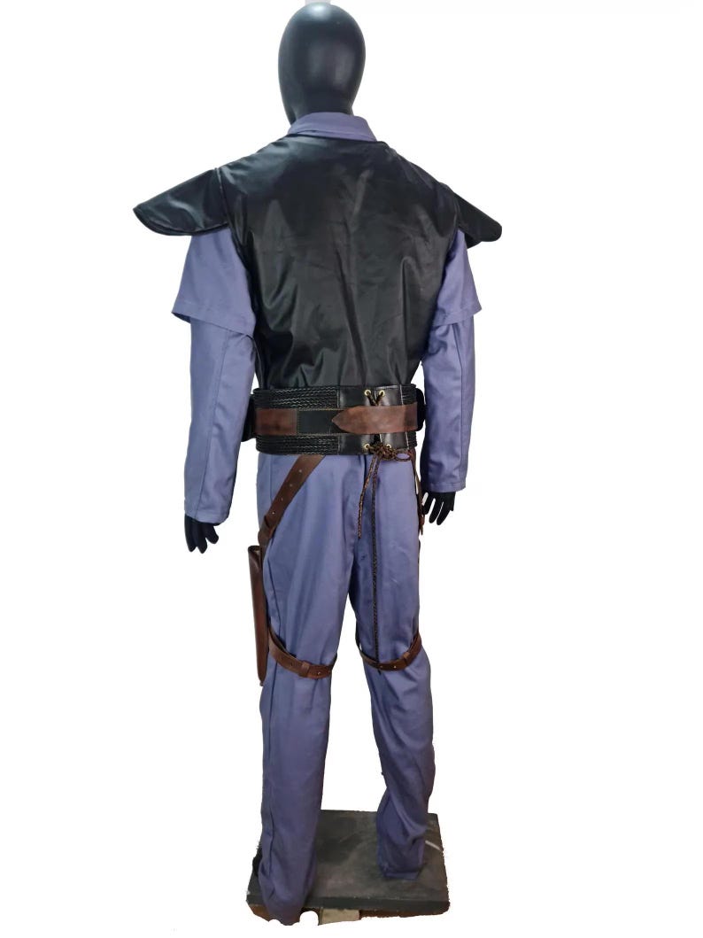 K&ouml;nnte beinhalten: Ein komplettes Kost&uuml;m, das auf einer Schaufensterpuppe pr&auml;sentiert wird. Das Kost&uuml;m umfasst einen hellblauen Overall, eine schwarze Weste und einen braunen G&uuml;rtel mit Holster. Das Kost&uuml;m hat auch braune Beingurte und schwarze Handschuhe. Die Schaufensterpuppe steht auf einem grauen Sockel.