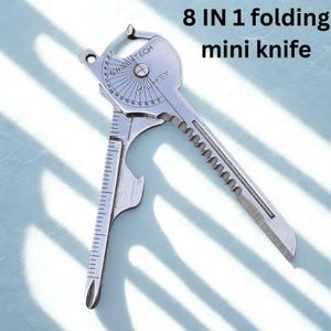 Peut inclure: Un mini couteau pliant 8 en 1 argenté. L'outil multifonction a une forme de clé avec une règle, un ouvre-bouteille et une lame dentelée. Le texte "SWISS TECH" et "UTIL-KEY" sont visibles sur l'outil.