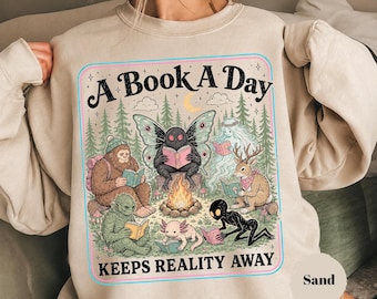 未確認生物読書クラブTシャツ、ビッグフット、モスマン、ジャッカロープのグラフィックTシャツ、面白い読書好き向けアパレル、キャンプファイヤー読書ギフト