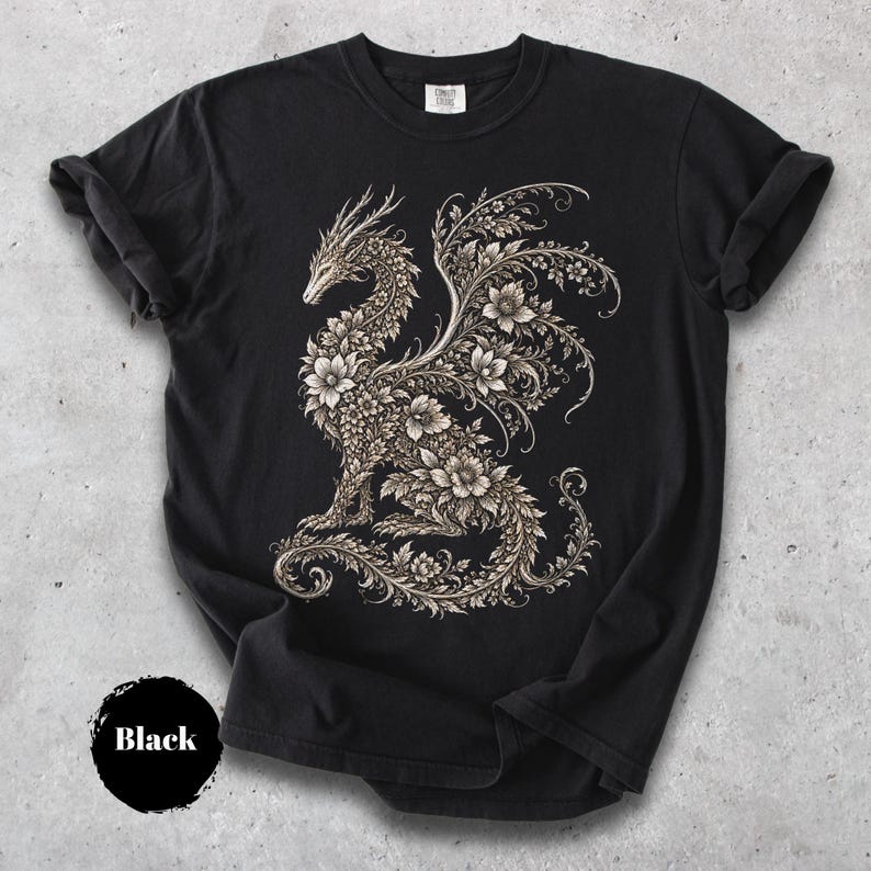 May include: A black short-sleeve t-shirt featuring a large, intricate graphic of a dragon composed entirely of detailed floral patterns and swirling vines in shades of cream and light beige, centered on the front of the garment.