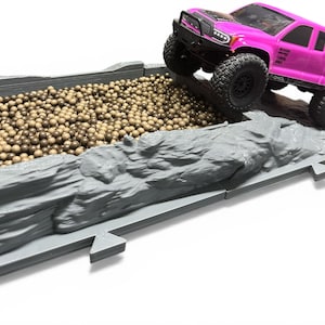 May include: A white ceramic mug with a black handle and the text "But First, Coffee" in a black, handwritten-style font. The mug is on a white surface.