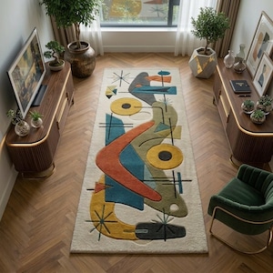 May include: A rectangular area rug featuring an off-white background with a multi-colored abstract pattern. The design includes geometric shapes in orange, teal, olive green, and yellow, accented by thin black lines and starburst motifs.