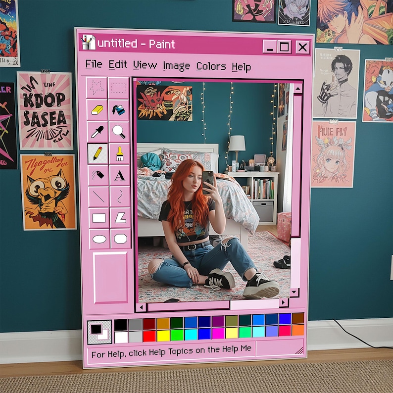 Puede incluir: Un espejo con marco rosa dise&ntilde;ado como una ventana de ordenador retro, con el texto "untitled - Paint" en la parte superior. El espejo refleja a una persona sentada en el suelo. La parte inferior del marco tiene una paleta de colores y el texto "For Help, click Help Topics on the Help Me".