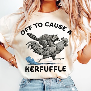 Puede incluir: Una taza de cerámica blanca con un asa negra y el texto "But First, Coffee" en negro, con una fuente de estilo manuscrito. La taza está sobre una superficie blanca.